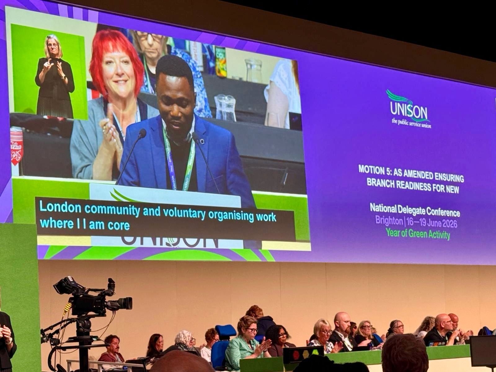 Joe Quarcoo addressing the 2026 UNISON National Delegate Conference, visible on the main conference screen.