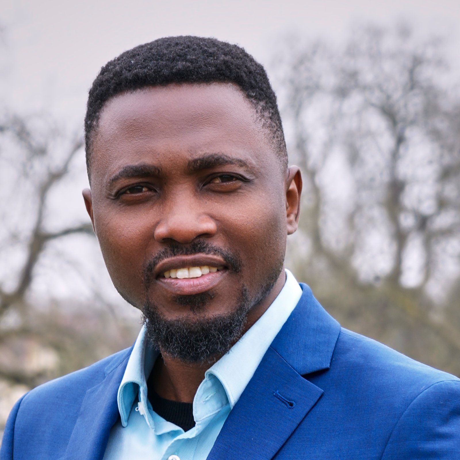 Professional headshot of Joe Quarcoo wearing a blue jacket.