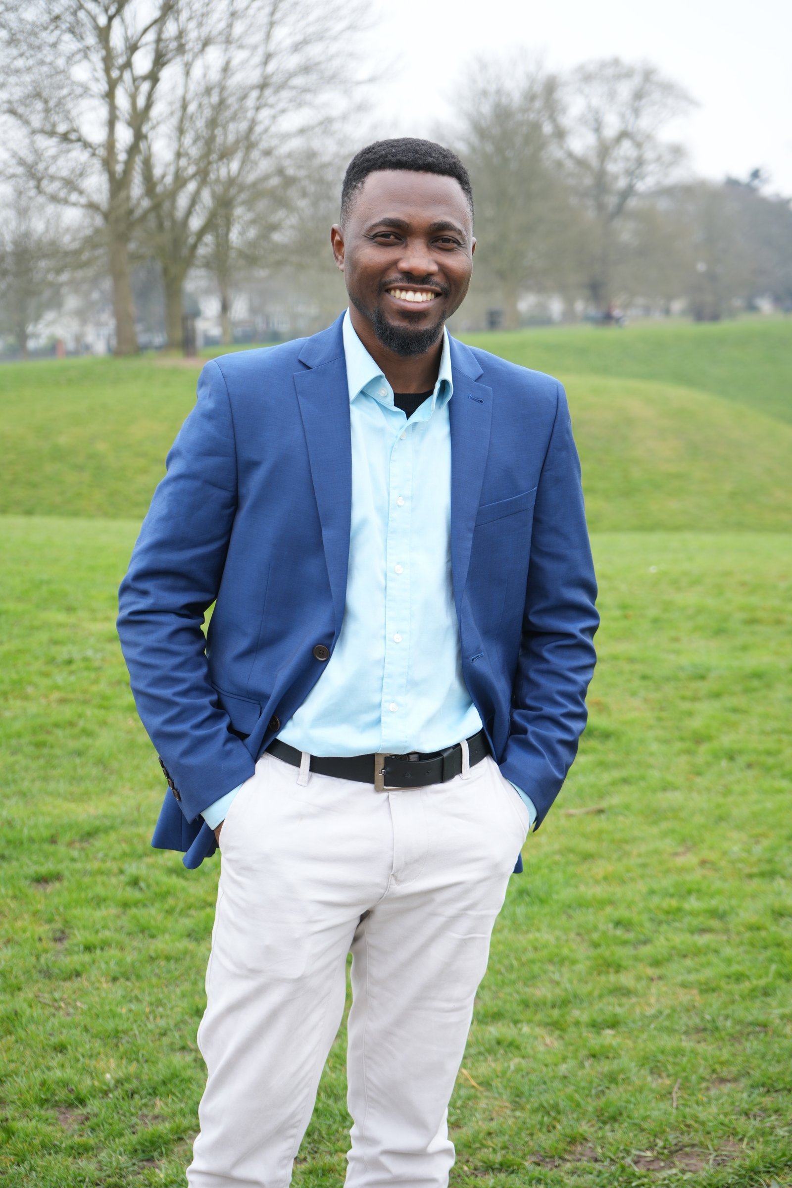 Joe Quarcoo standing outdoors in a blue jacket.
